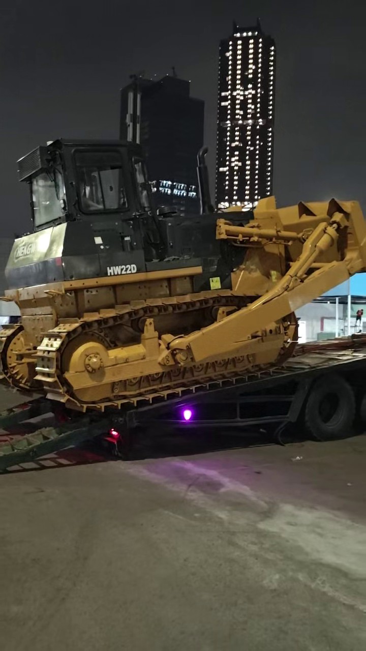 HW22D crawler bulldozer loaded on flatbed at night